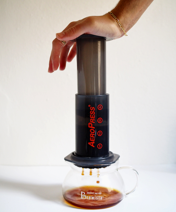 estrazione con AeroPress: una mano preme sul pistone